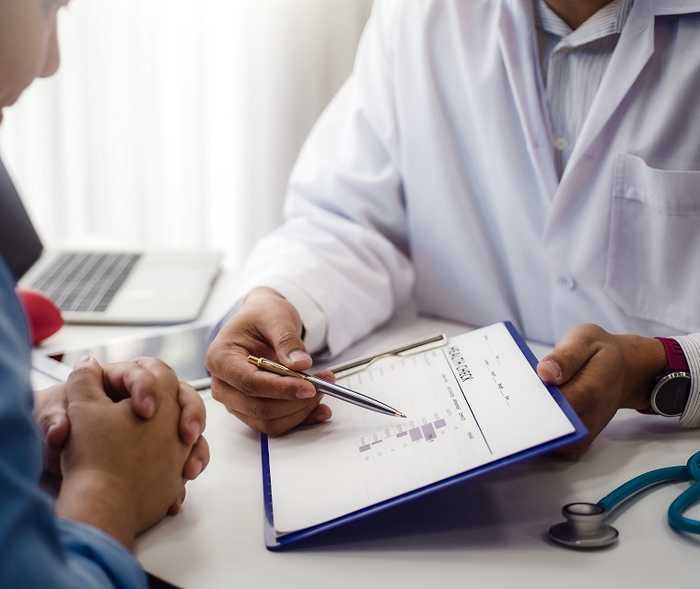 Das Bild zeigt einen Arzt, der seinem Patienten etwas erklärt