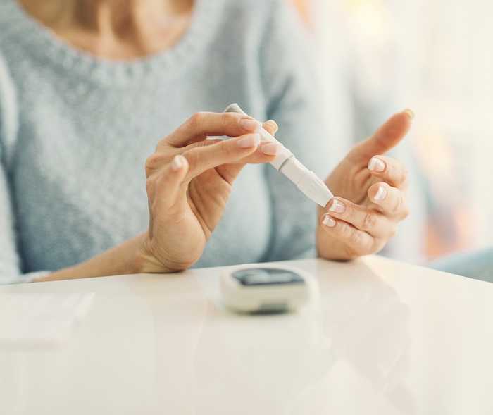 Foto von der Blutzuckermessung mit Stechhilfe am Finger