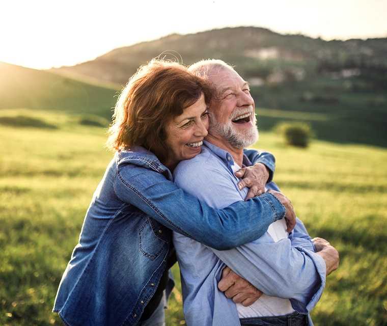 Ehepaar lacht herzlichen und umarmt sich